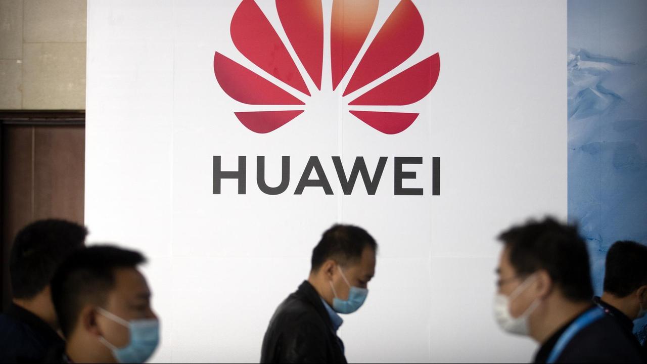 Menschen vor einer Werbetafel mit dem Huawei-Logo auf der PT Expo in Peking. Menschen vor einer Werbetafel mit dem Huawei-Logo auf der PT Expo in Peking.