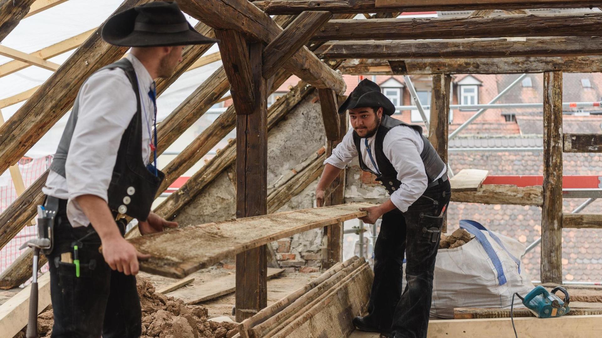 Zwei Zimmermannsgesellen, die auf Wanderschaft sind, arbeiten auf einer Baustelle in Bamberg. Zwei Zimmermannsgesellen, die auf Wanderschaft sind, arbeiten auf einer Baustelle in Bamberg.