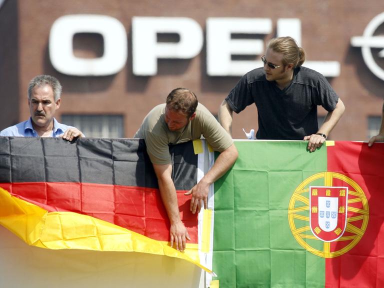 Deutsche und portugiesische Arbeiter protestieren 2006 gemeinsam in Rüsselsheim gegen die drohende Schließung eines Werks in Portugal.