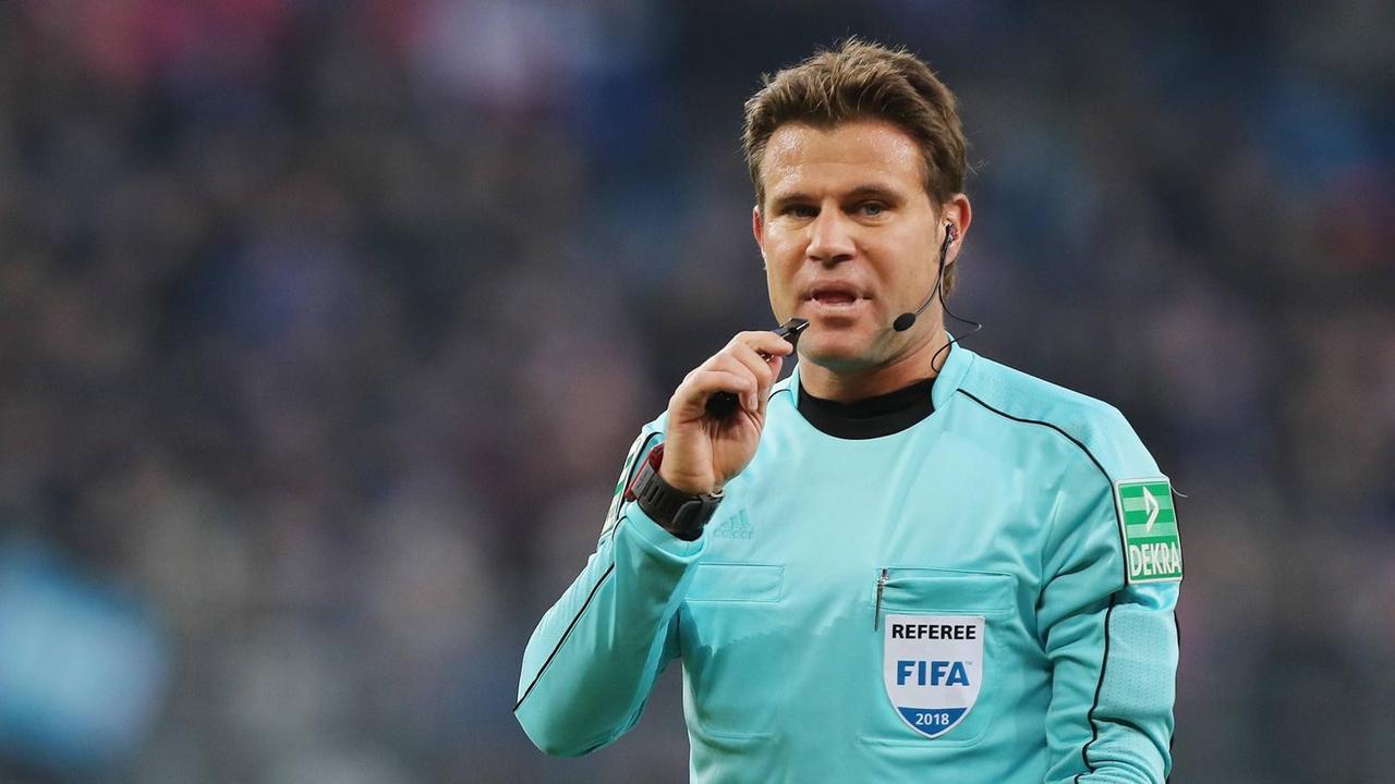 Schiedsrichter Felix Brych mit Pfeife im Mund während eines Bundesliga-Spiels Schiedsrichter Felix Brych mit Pfeife im Mund während eines Bundesliga-Spiels