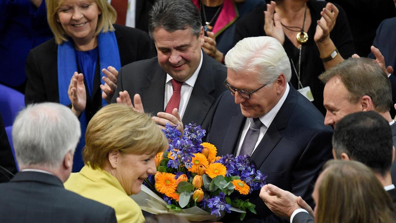 Frank-Walter Steinmeier (M) nimmt in Berlin nach seiner Wahl zum künftigen Bundespräsidenten den Glückwunsch von Bundeskanzlerin Angela Merkel entgegen.