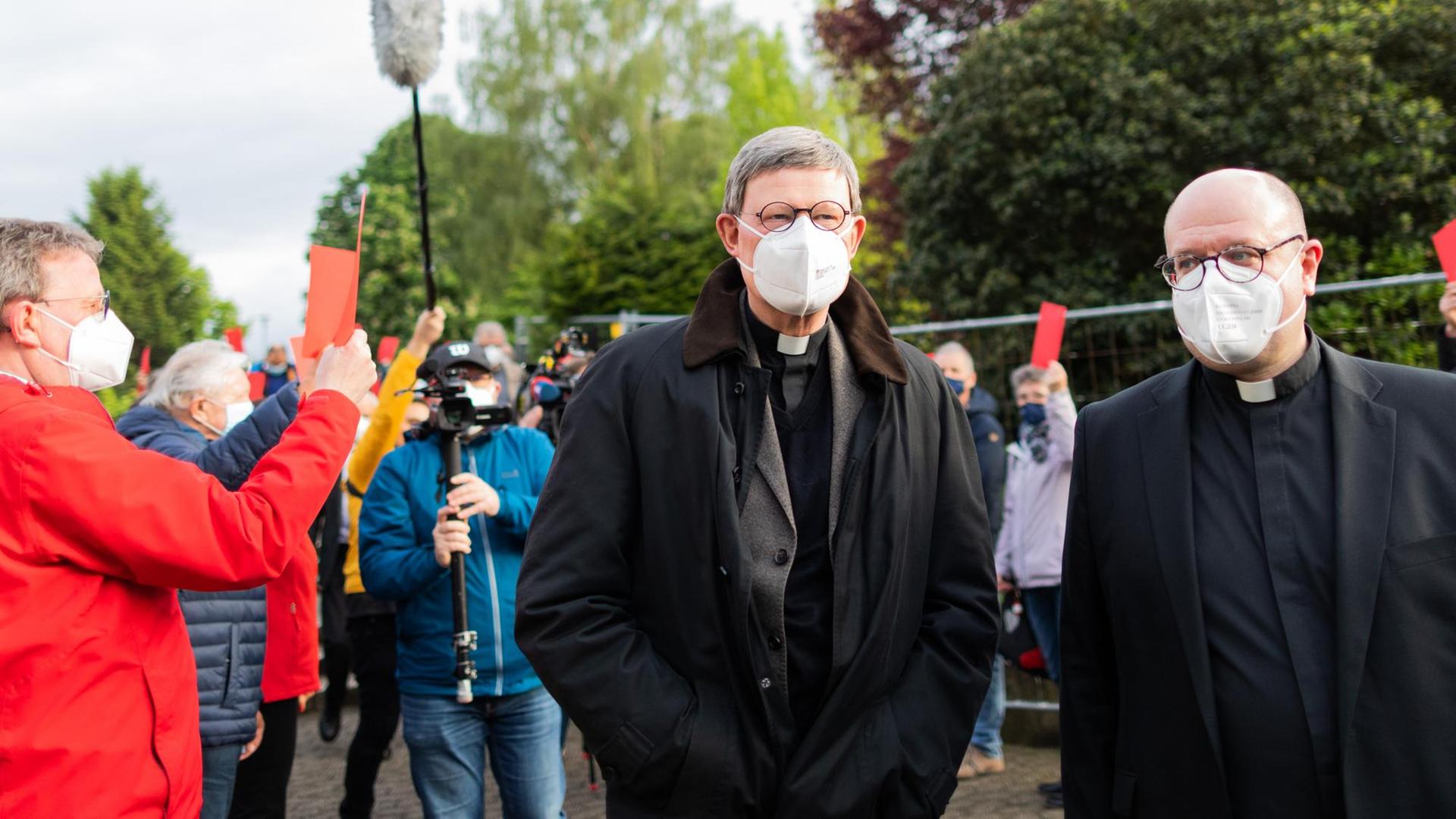 Kardinal Rainer Maria Woelki (l), Erzbischof von Köln, und Pfarrer Oliver Boss gehen durch einen Spalier aus Gemeindemitgliedern, die ihm vor der Kirche St. Maria vom Frieden die Rote Karte zeigen. Woelki besucht die Gemeinde zu einem Krisengespräch. Mehr als 140 Gemeindemitglieder hatten ihn in einem Offenen Brief aufgefordert, auf die von ihm geplante Firmung von 17 Jugendlichen am 9. Juni zu verzichten. Kardinal Rainer Maria Woelki (l), Erzbischof von Köln, und Pfarrer Oliver Boss gehen durch einen Spalier aus Gemeindemitgliedern, die ihm vor der Kirche St. Maria vom Frieden die Rote Karte zeigen. Woelki besucht die Gemeinde zu einem Krisengespräch. Mehr als 140 Gemeindemitglieder hatten ihn in einem Offenen Brief aufgefordert, auf die von ihm geplante Firmung von 17 Jugendlichen am 9. Juni zu verzichten.