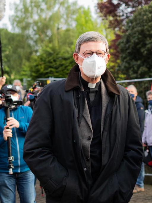 Kardinal Rainer Maria Woelki (l), Erzbischof von Köln, und Pfarrer Oliver Boss gehen durch einen Spalier aus Gemeindemitgliedern, die ihm vor der Kirche St. Maria vom Frieden die Rote Karte zeigen. Woelki besucht die Gemeinde zu einem Krisengespräch. Mehr als 140 Gemeindemitglieder hatten ihn in einem Offenen Brief aufgefordert, auf die von ihm geplante Firmung von 17 Jugendlichen am 9. Juni zu verzichten.