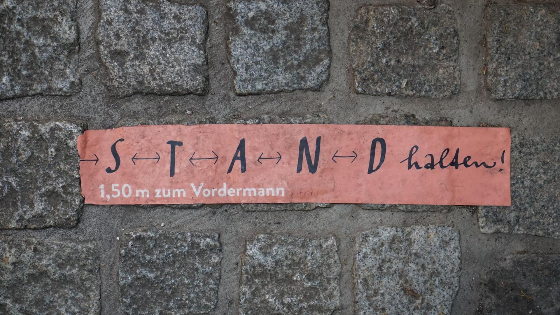 Aufkleber mit den Worten „S T A N D halten“ auf Kopfsteinpflaster in Erfurt. Aufkleber mit den Worten „S T A N D halten“ auf Kopfsteinpflaster in Erfurt.