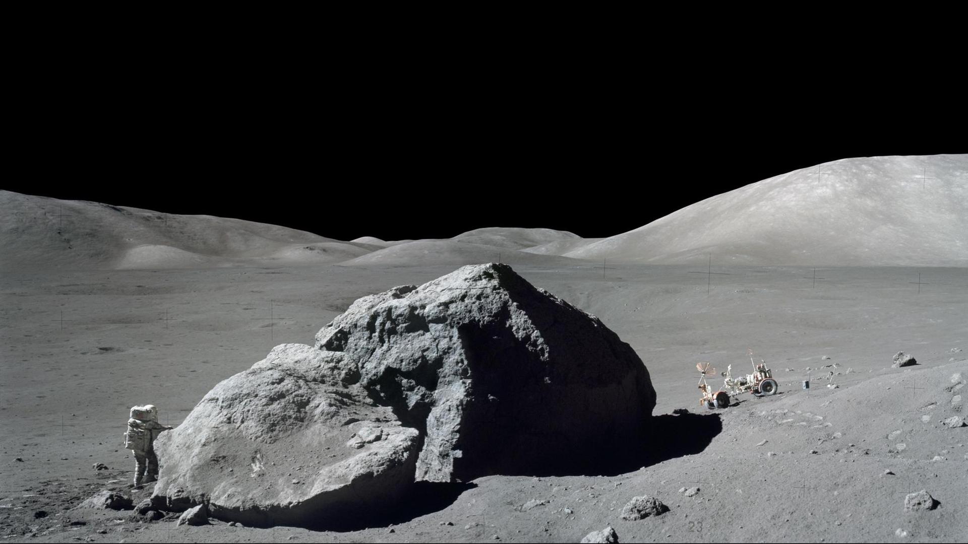 Ein Astronaut neben einem Felsen auf dem Mond Ein Astronaut neben einem Felsen auf dem Mond