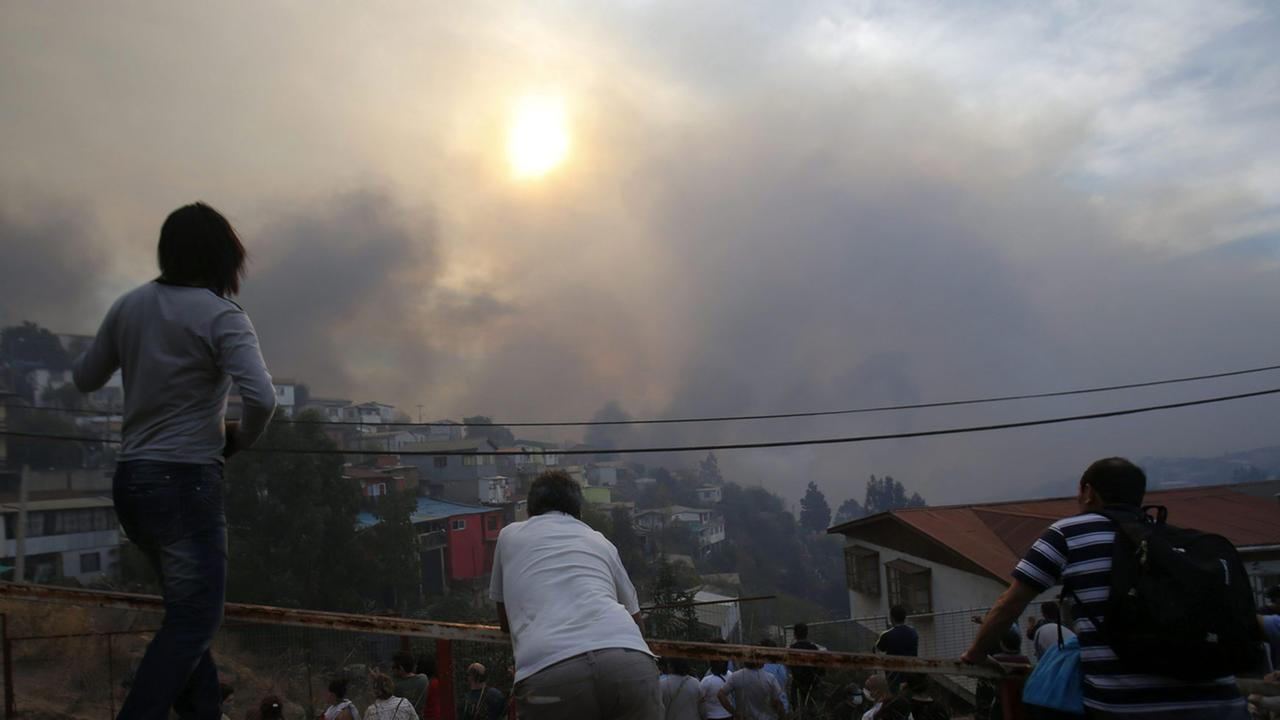 Menschen beobachten den Großbrand auf dem Ramaditos-Hügel in der chilenischen Hafenstadt Valparaíso.