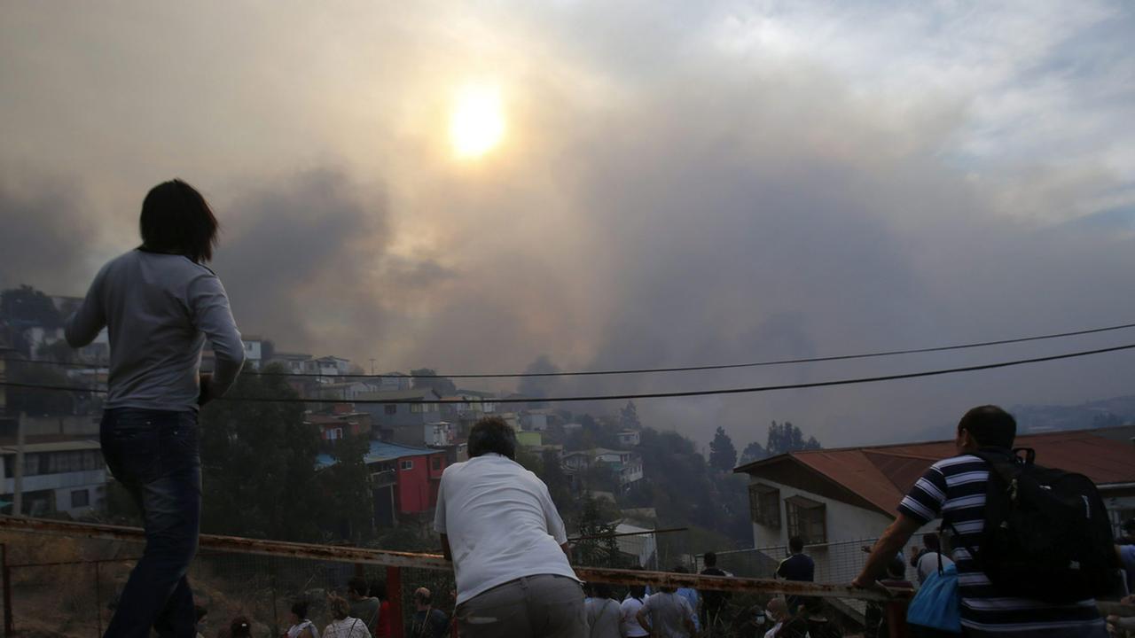 Menschen beobachten den Großbrand auf dem Ramaditos-Hügel in der chilenischen Hafenstadt Valparaíso. Menschen beobachten den Großbrand auf dem Ramaditos-Hügel in der chilenischen Hafenstadt Valparaíso.