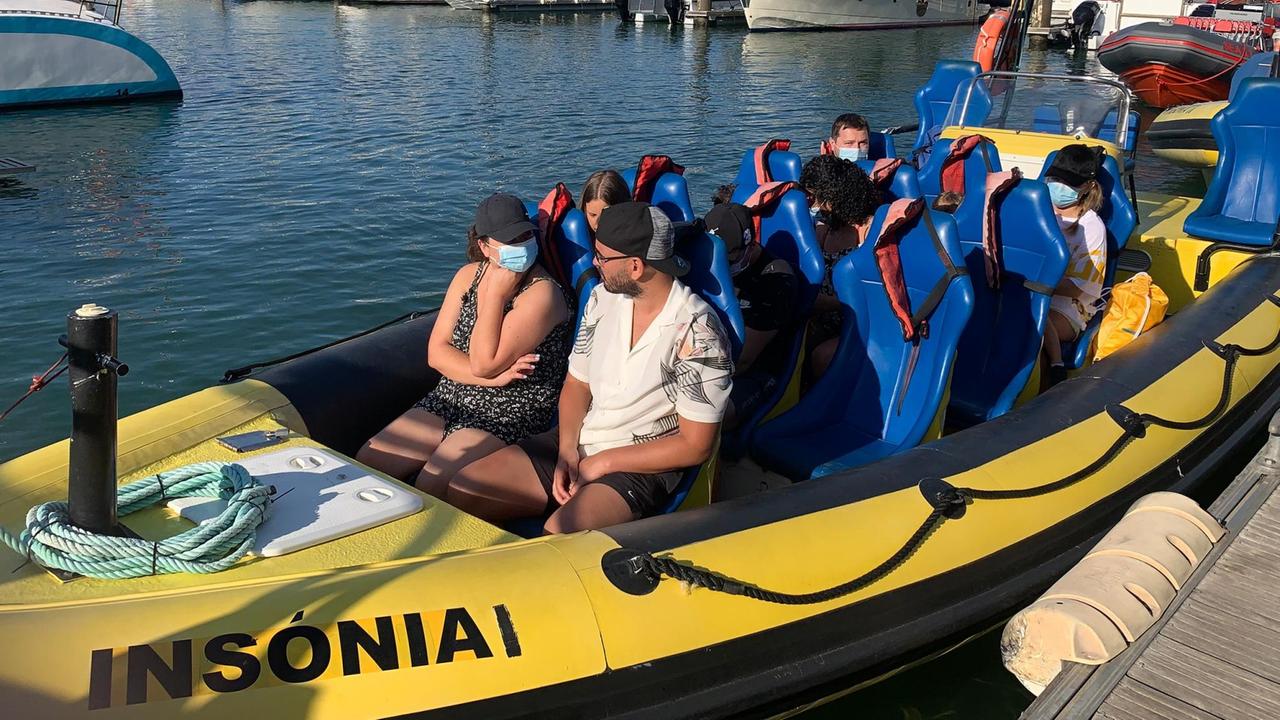 In einem Boot in einem Hafen sitzen wenige Touristen. In einem Boot in einem Hafen sitzen wenige Touristen.