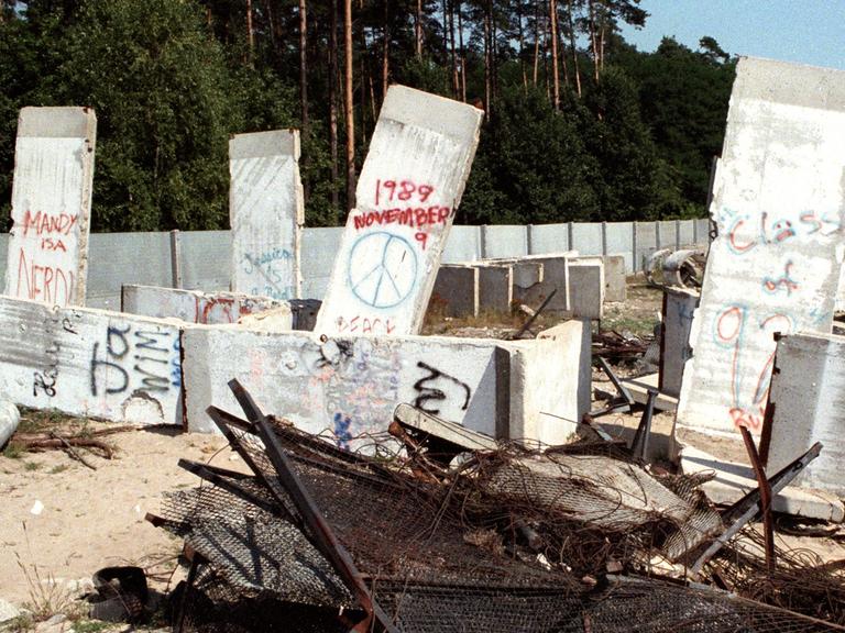 Trümmer der Geschichte - Teile der Betonmauer, Stacheldraht, Gitterzaun und Betonreste der Berliner Mauer liegen im Ortsteil Steinstücken bei Potsdam auf einem Gelände, aufgenommen im August 1990.