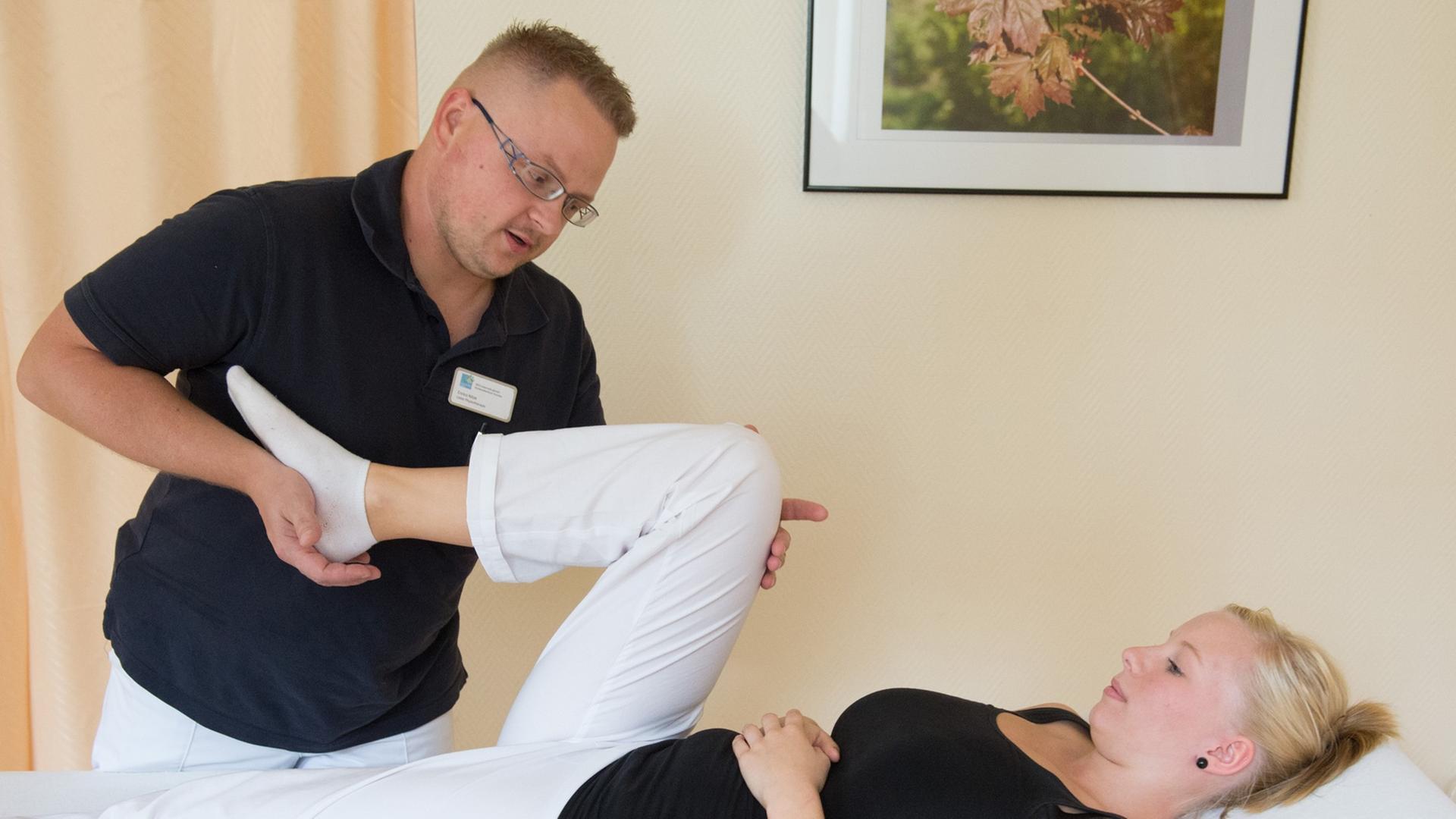Ein Physiotherapeut behandelt Knieprobleme einer jungen Patientin. Ein Physiotherapeut behandelt Knieprobleme einer jungen Patientin.