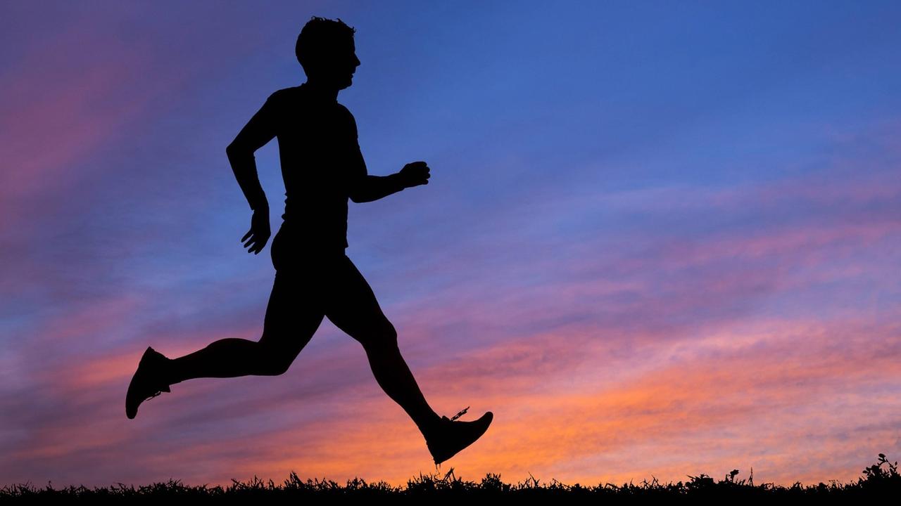 Silhouette eines Joggers im Sonnenuntergang. Silhouette eines Joggers im Sonnenuntergang.