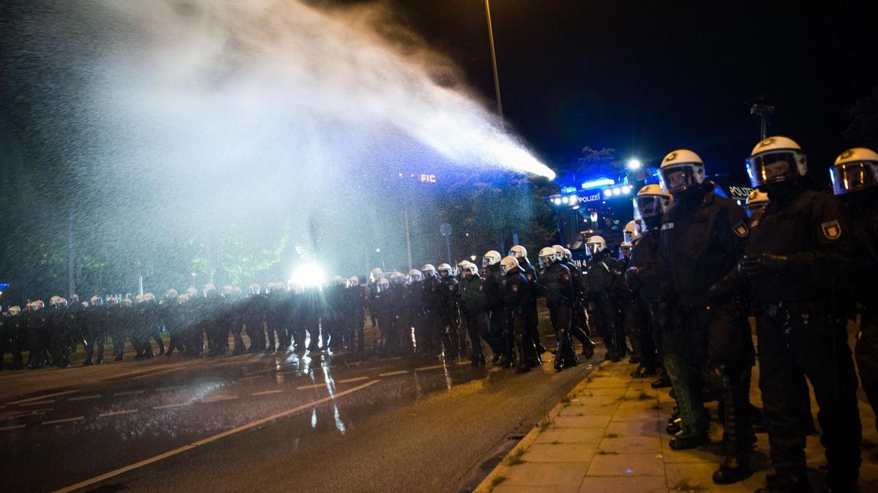 Ein Wasserwerfer der Polizei spritzt am in Hamburg am Neuen Pferdemarkt im Stadtteil St. Pauli Wasser auf eine Menschenmenge. Ein Wasserwerfer der Polizei spritzt am in Hamburg am Neuen Pferdemarkt im Stadtteil St. Pauli Wasser auf eine Menschenmenge.