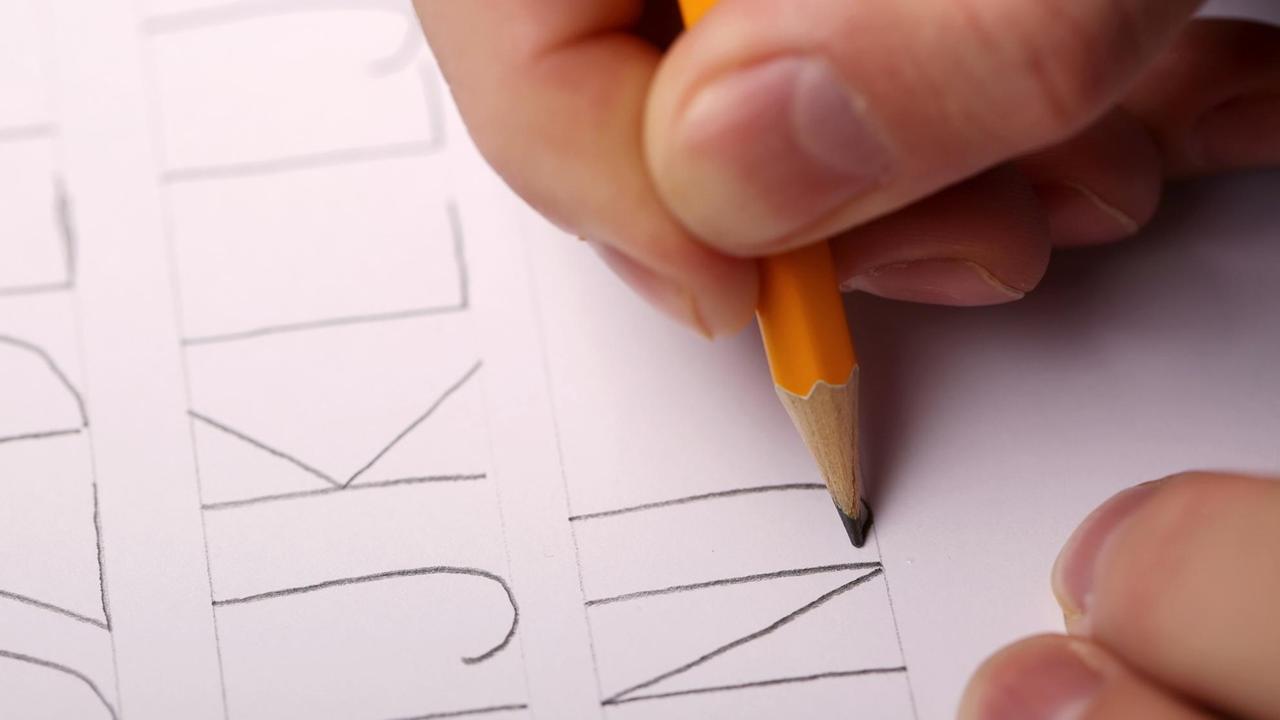 Hand schreibt Großbuchstaben Hand schreibt Großbuchstaben
