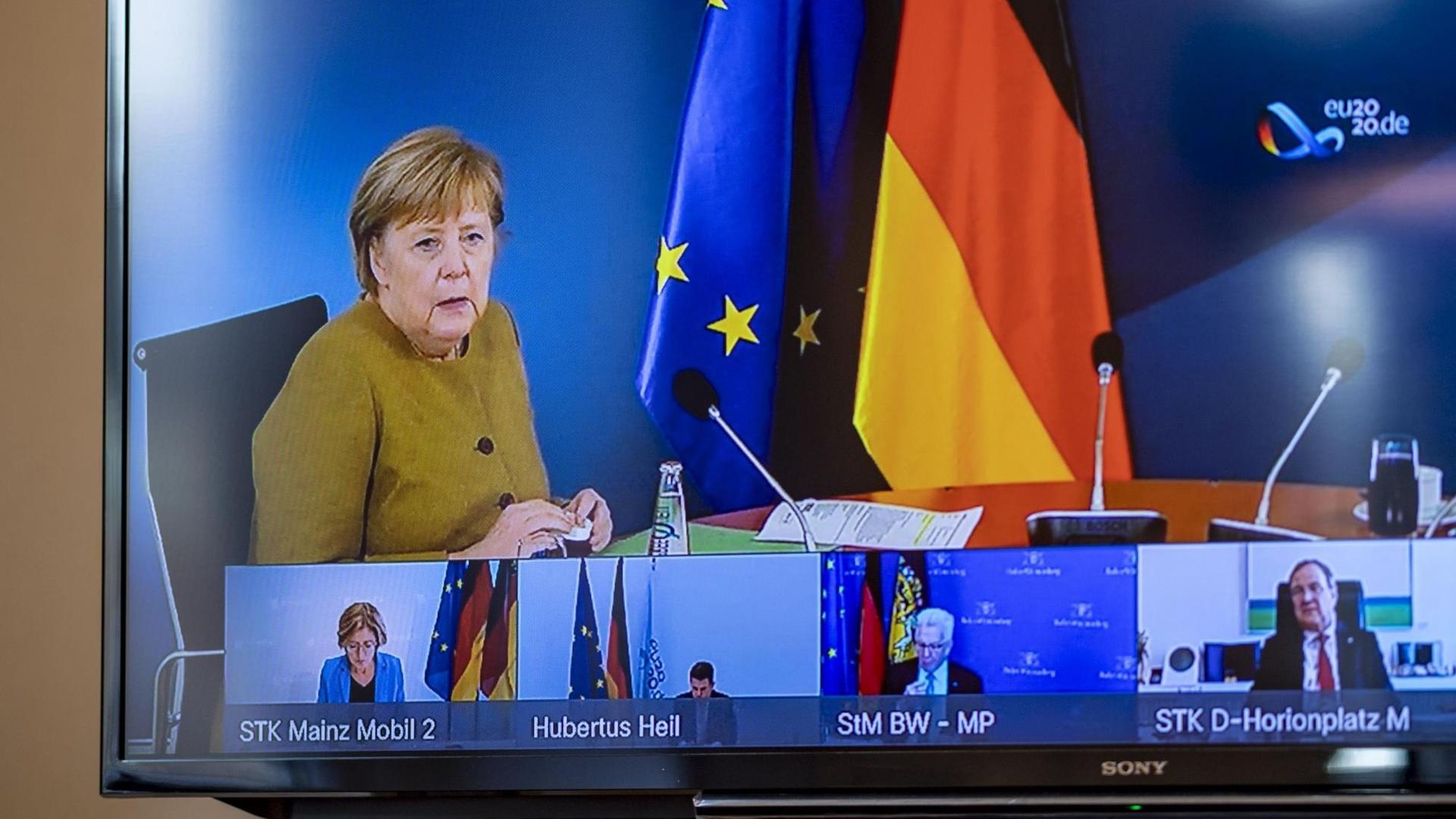 Schleswig-Holstein, Kiel: Angela Merkel (CDU), Bundeskanzlerin, spricht bei Beratungen der deutschen Ministerpräsidenten in einer Videokonferenz und ist dabei auf einem Monitor in der Staatskanzlei in Kiel zu sehen. Schleswig-Holstein, Kiel: Angela Merkel (CDU), Bundeskanzlerin, spricht bei Beratungen der deutschen Ministerpräsidenten in einer Videokonferenz und ist dabei auf einem Monitor in der Staatskanzlei in Kiel zu sehen.