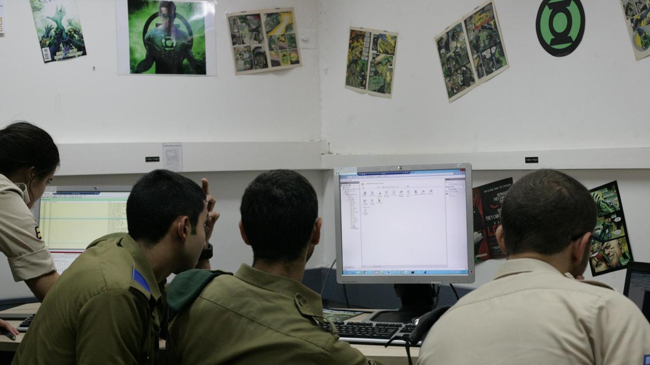 Eine Gruppe von israelischen Soldaten sitzt vor einem Computermonitor.