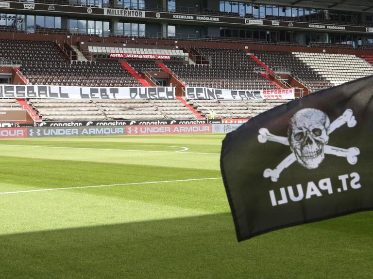 Spiel ohne Fans: FC St. Pauli gegen 1. FC Nürnberg Hamburg am 17. Mai 2020. Auf den Rängen ist ein Banner mit der Aufschrift "Fußball lebt durch seine Fans. Reformen jetzt" zu sehen.