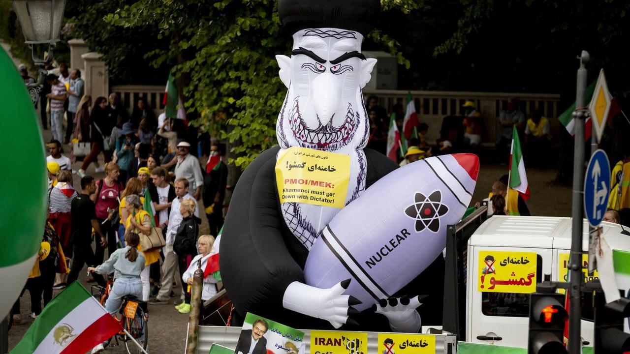 Eine aufblasbare Figur von Ali Chamene’i mit einer Atombombe steht bei einer Kundgebung für den Aufstand und Widerstand der Bürger im Iran am Brandenburger Tor. Zu der Kundgebung hat der Nationale Widerstandsrat Iran (NWRI) aufgerufen.
