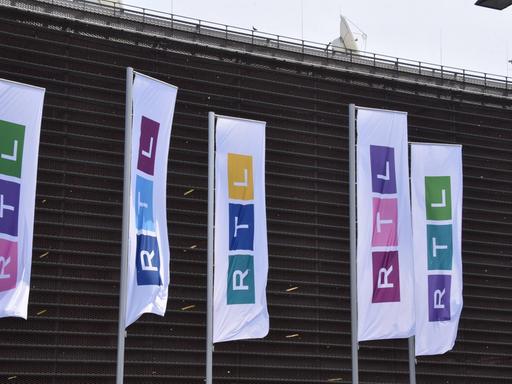 Fahnen mit dem neuen RTL-Logo wehen vor dem Gebäude des Senders in Köln.