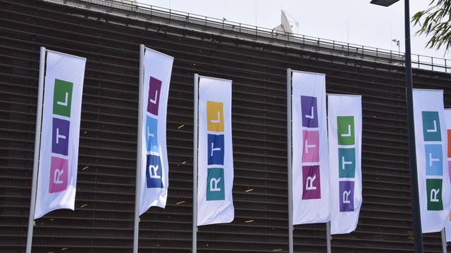 Fahnen mit dem neuen RTL-Logo wehen vor dem Gebäude des Senders in Köln.