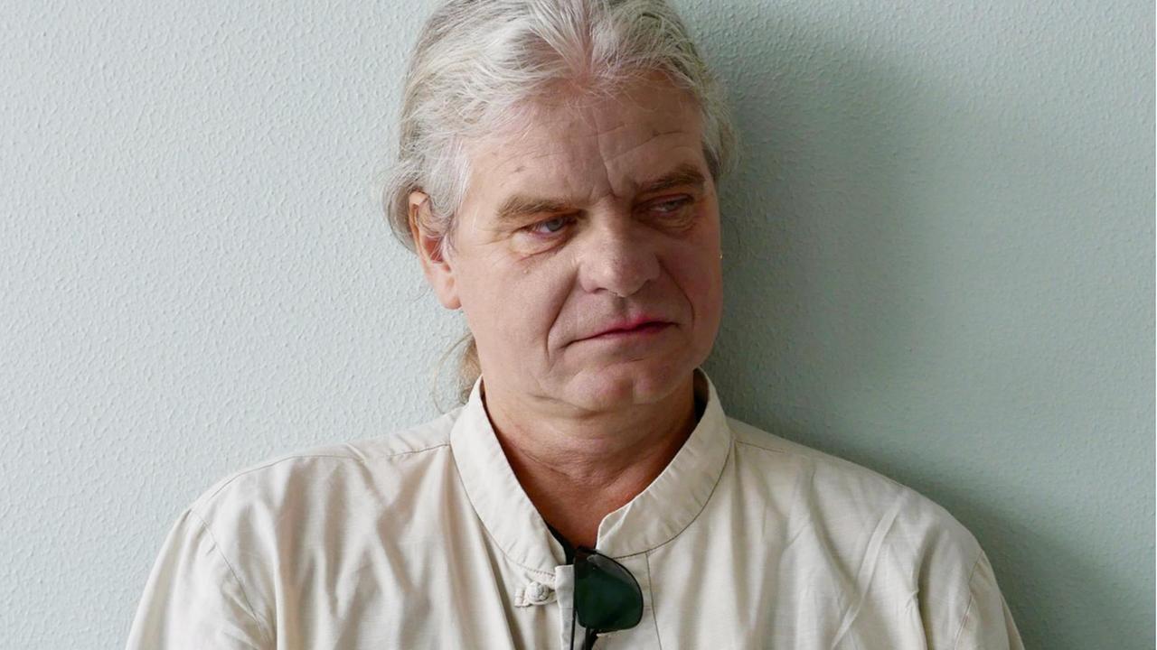 Der Religionswissenschaftler Volker Küster trägt sein weißes Haar im Nacken zu einem Zopf gebunden, im Kragen seines weißen Hemdes, steckt eine dunkle Sonnenbrille, sein Blick ist nachdenklich zur Seite gewandt. Der Religionswissenschaftler Volker Küster trägt sein weißes Haar im Nacken zu einem Zopf gebunden, im Kragen seines weißen Hemdes, steckt eine dunkle Sonnenbrille, sein Blick ist nachdenklich zur Seite gewandt.