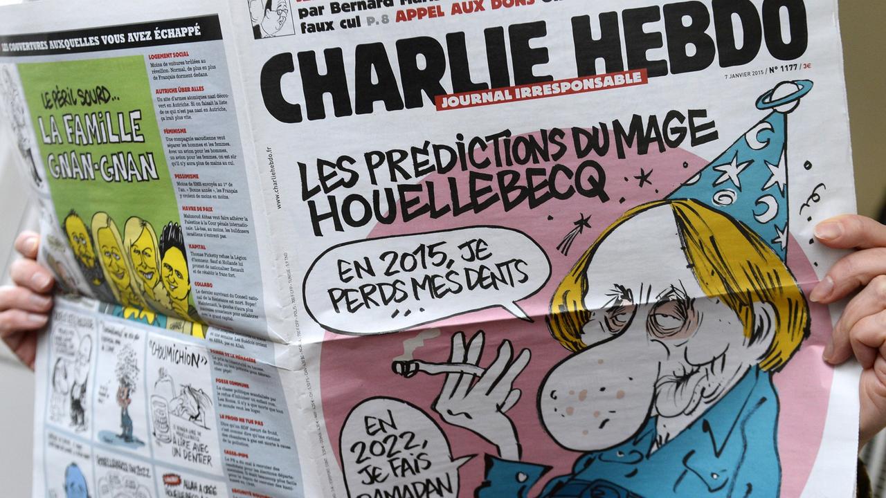 Eine Person hält die letzte Ausgabe der Satirezeitschrift "Charlie Hebdo" vom 7. Januar 2015 in Händen. Eine Person hält die letzte Ausgabe der Satirezeitschrift "Charlie Hebdo" vom 7. Januar 2015 in Händen.