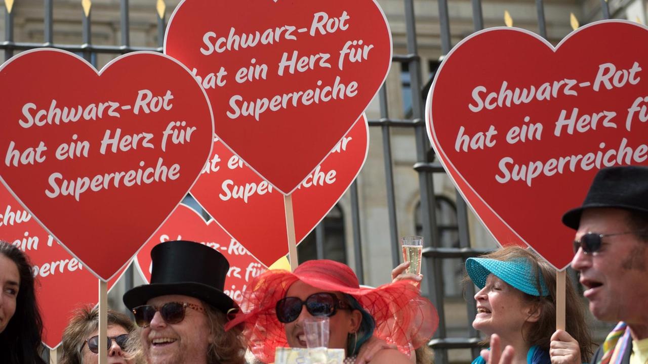 Demonstranten halten am 30.06.2016 vor dem Bundesrat in Berlin Herzen mit der Aufschrift «Schwarz-Rot hat ein Herz für Superreiche». Die Organisation Attac hatte zu einer Protestaktion gegen das geplante Erbschaftssteuer-Gesetz aufgerufen. Anlass war ein Treffen der Finanzminister, bei dem sie die Abstimmung über das Erbschaftssteuergesetz am 8. Juli im Bundesrat vorbereiten wollten. Demonstranten halten am 30.06.2016 vor dem Bundesrat in Berlin Herzen mit der Aufschrift «Schwarz-Rot hat ein Herz für Superreiche». Die Organisation Attac hatte zu einer Protestaktion gegen das geplante Erbschaftssteuer-Gesetz aufgerufen. Anlass war ein Treffen der Finanzminister, bei dem sie die Abstimmung über das Erbschaftssteuergesetz am 8. Juli im Bundesrat vorbereiten wollten.