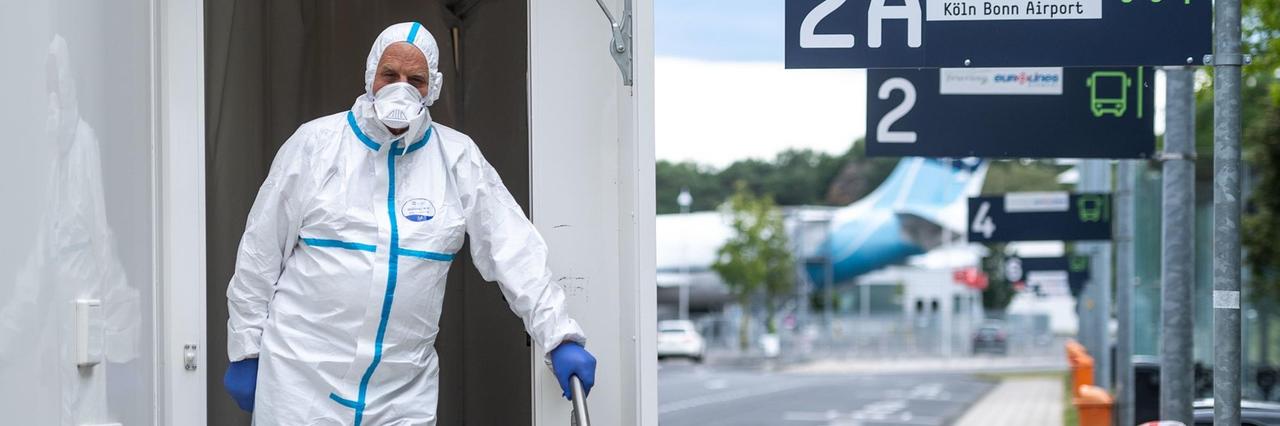 Ein Mitarbeiter des Corona-Testzentrum am Flughafen Köln/Bonn steht im Eingang des Testzentrums. Ein Mitarbeiter des Corona-Testzentrum am Flughafen Köln/Bonn steht im Eingang des Testzentrums.