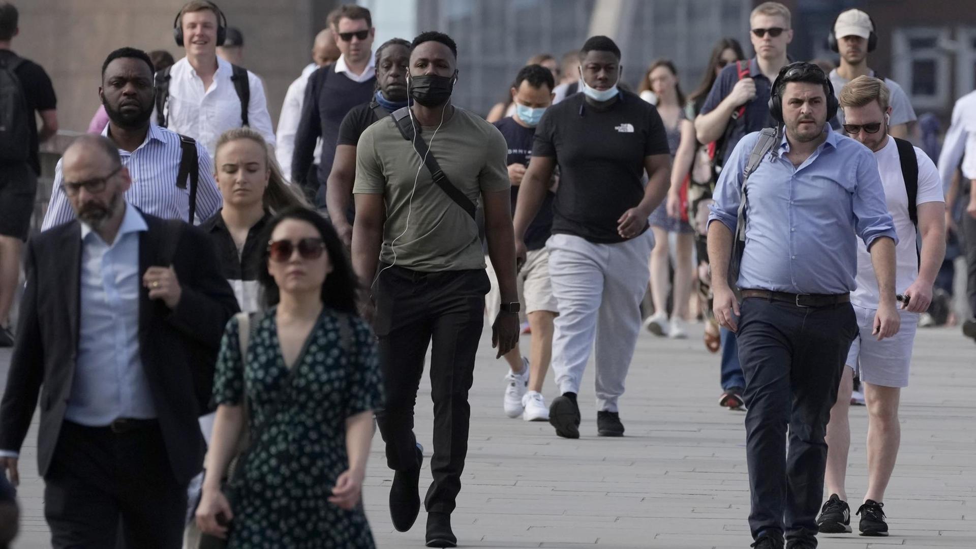 Viele Menschen gehen ohne Maske auf einer Straße in London. Viele Menschen gehen ohne Maske auf einer Straße in London.
