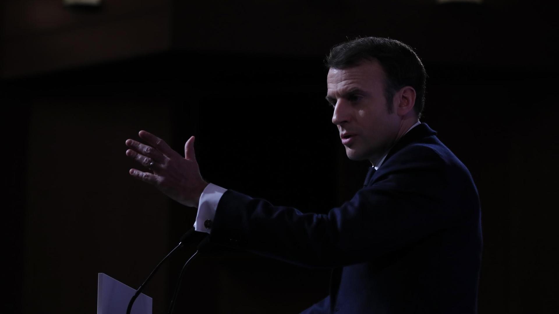 Frankreichs Präsident Macron ist während einer Rede von der Seite zu sehen. Er spricht mit seinen Händen gestikulierend in Mikrofone. Frankreichs Präsident Macron ist während einer Rede von der Seite zu sehen. Er spricht mit seinen Händen gestikulierend in Mikrofone.