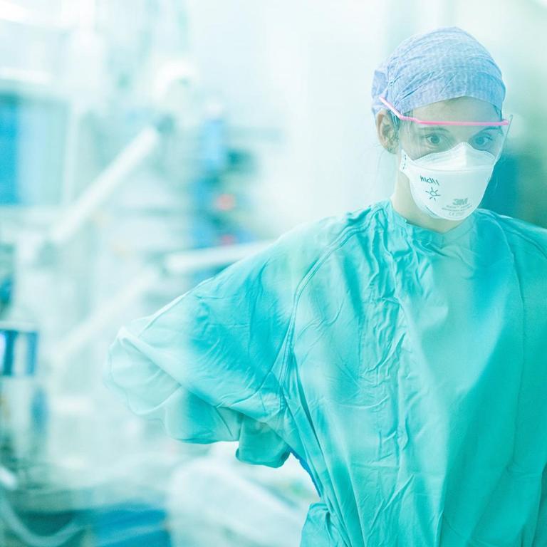 Intensivpflegerin steht  auf der Covid-Intensivstation der Dresdner Uniklinik vor einem Bett 