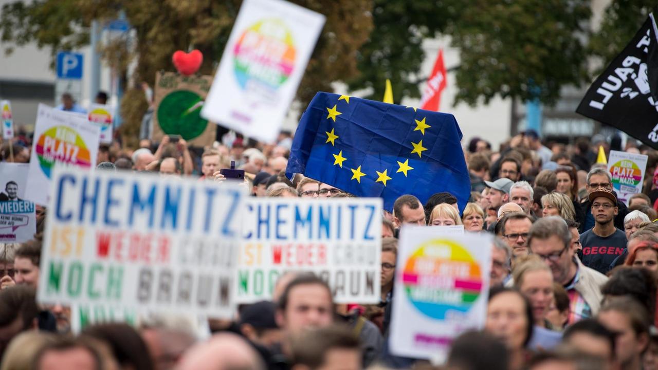 Teilnehmer der Kundgebung des Bündnisses "Chemnitz Nazifrei", am 1. September 2018, halten Schilder und eine Flagge der EU hoch. Teilnehmer der Kundgebung des Bündnisses "Chemnitz Nazifrei", am 1. September 2018, halten Schilder und eine Flagge der EU hoch.