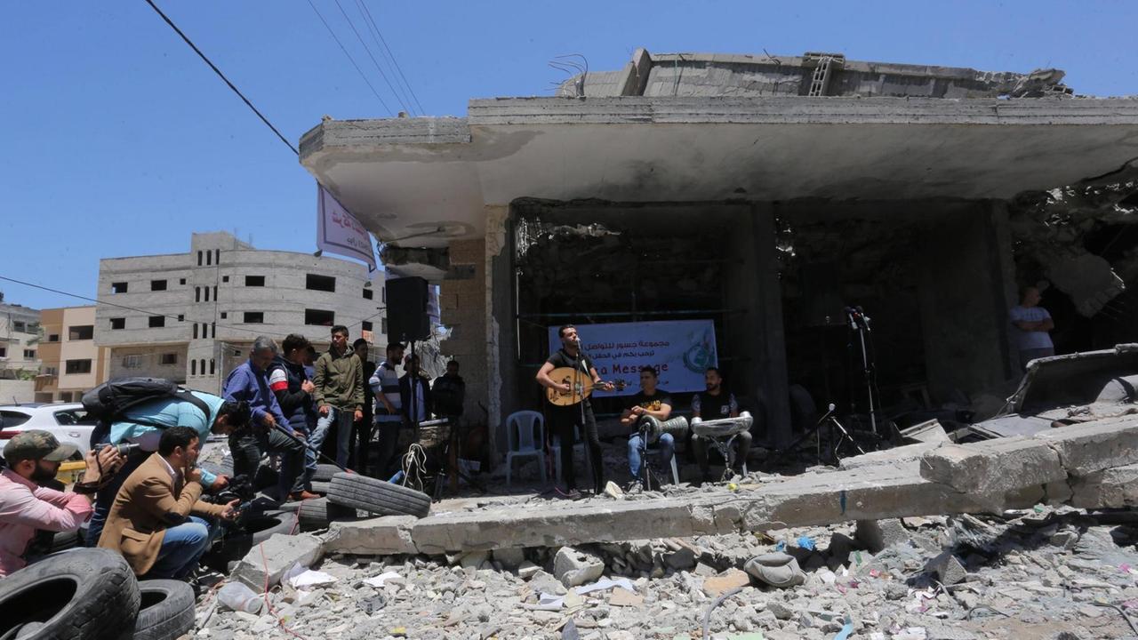 Mitglieder der Band "Dawaween" spielen am 14. Mai nach den Bombenangriffen in Gaza-Stadt vor einem zerstörten Gebäude und haben zum Boykott des ESC aufgerufen. Mitglieder der Band "Dawaween" spielen am 14. Mai nach den Bombenangriffen in Gaza-Stadt vor einem zerstörten Gebäude und haben zum Boykott des ESC aufgerufen.