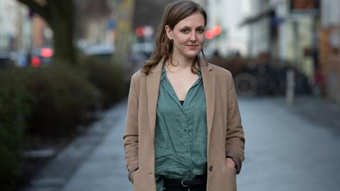 Die Autorin und freie Journalistin Valerie Schönian steht in Berlin an einer Straße.