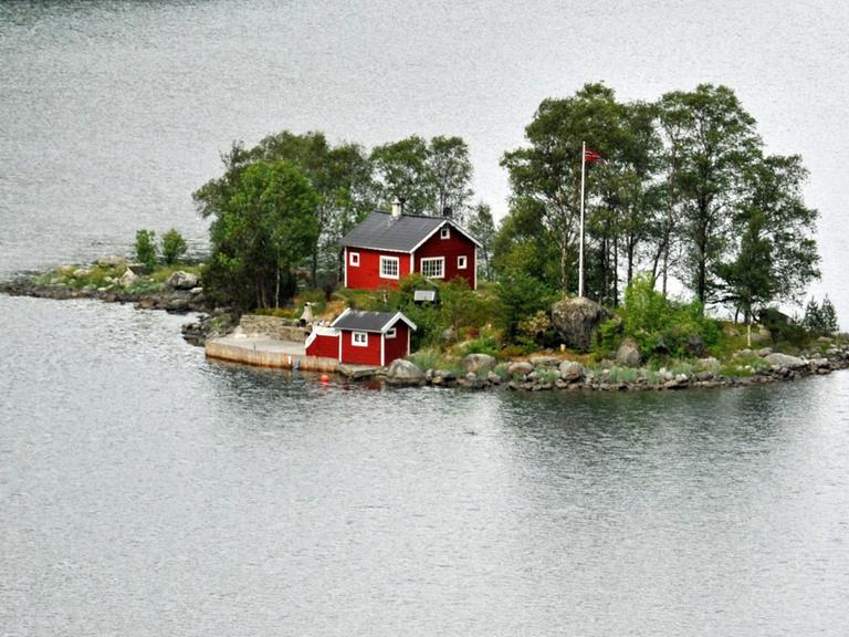 Eine Insel mit roten Holzhäusern in einem norwegischen Fjord