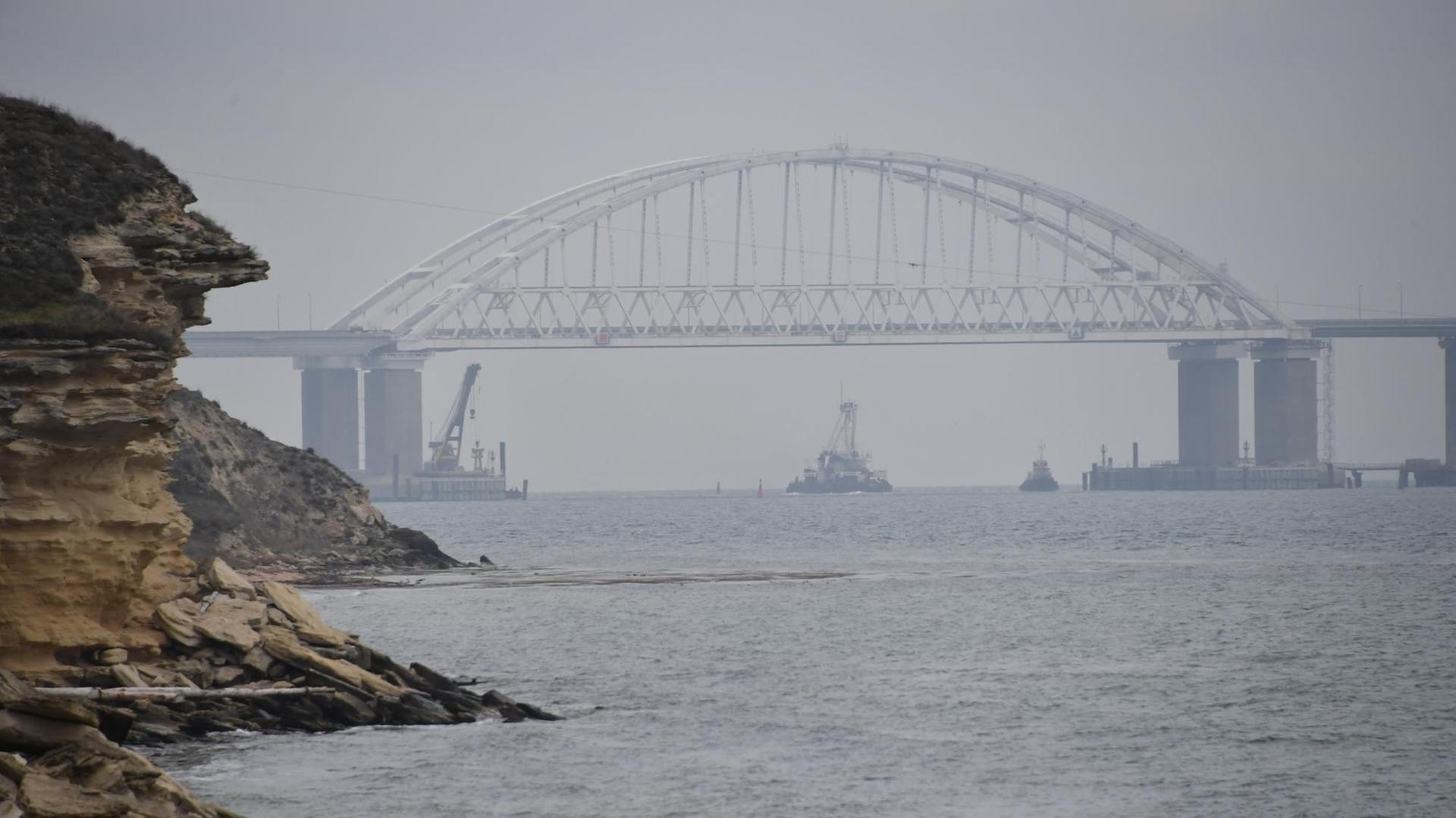 Ein Schiff fährt unter der Brücke über die Meerenge von Kertsch.