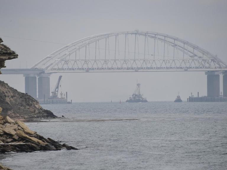 Ein Schiff fährt unter der Brücke über die Meerenge von Kertsch.