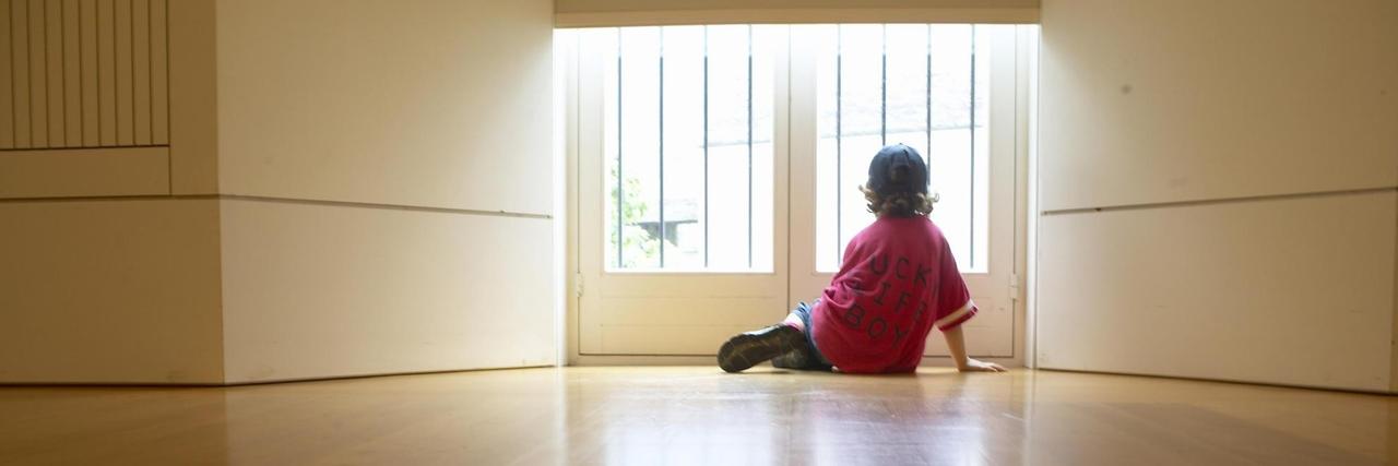 Junge am Fenster blickt nach draußen Junge am Fenster blickt nach draußen