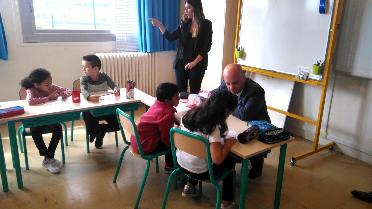 Erziehungsminister Jean-Michel Blanquer spricht in einer Klasse mit Schülerinnen und Schülern.
