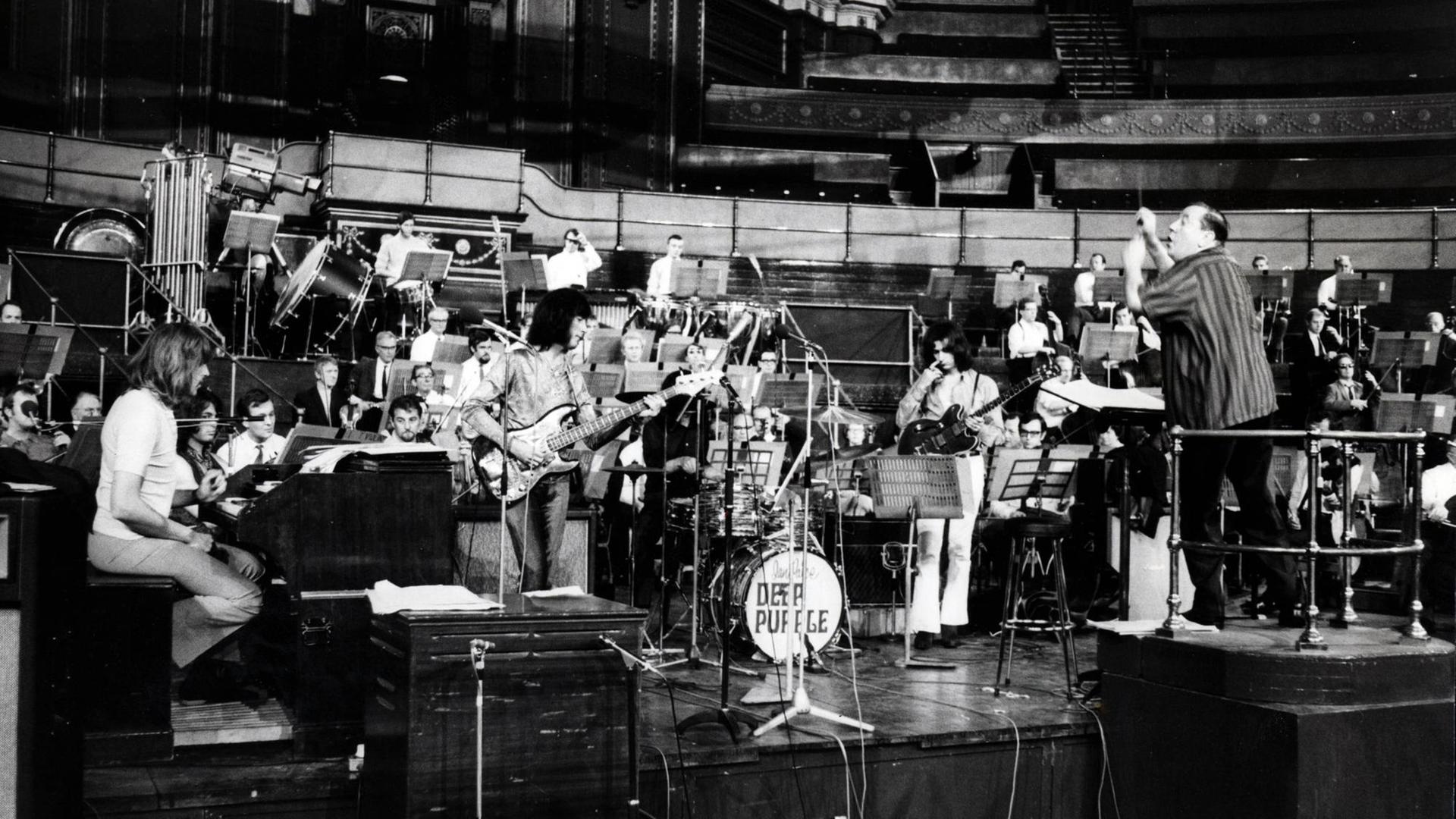 Schwarz-weiß Foto von der Band Deep Purple und Mitgliedern des Royal Philharmonic Orchestra in der Royal Albert Hall. Mitglieder der Rockband und Sir Malcolm Arnold tragen legere Kleidung, die Mitglieder des Orchester Anzug mit Schlips, mit und ohne Jacket Schwarz-weiß Foto von der Band Deep Purple und Mitgliedern des Royal Philharmonic Orchestra in der Royal Albert Hall. Mitglieder der Rockband und Sir Malcolm Arnold tragen legere Kleidung, die Mitglieder des Orchester Anzug mit Schlips, mit und ohne Jacket