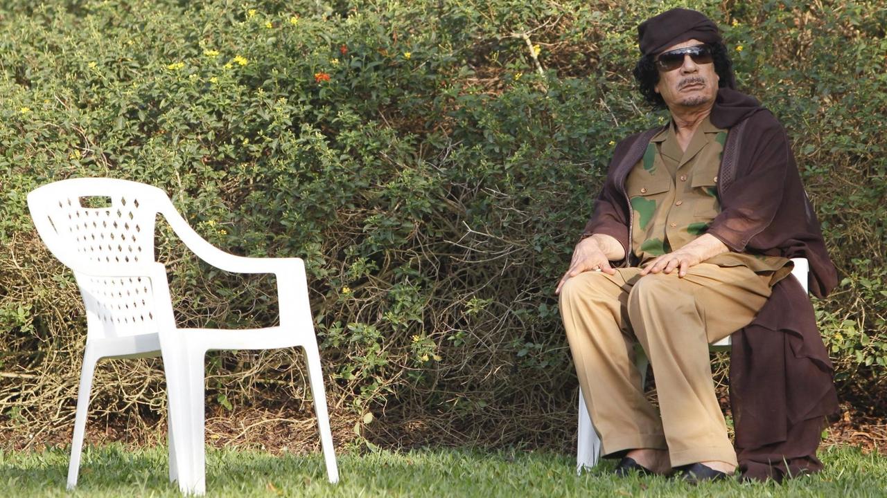 Der ehemalige libysche Präsident Muammar al-Gaddafi sitzt auf einem Stuhl