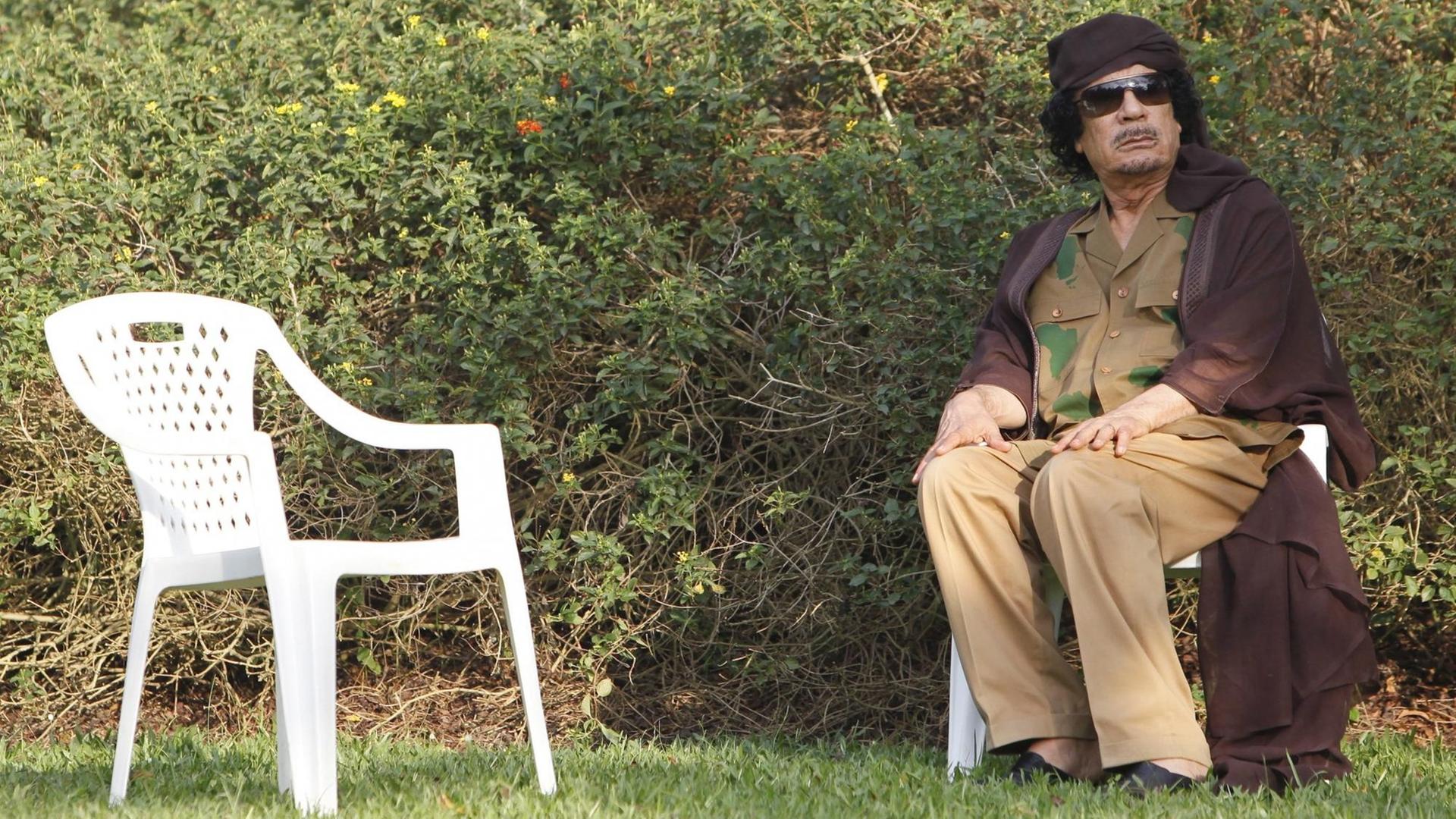 Der ehemalige libysche Präsident Muammar al-Gaddafi vor einem Treffen mit dem damaligen Präsidenten Tansanias Jakaya Kikwete (nicht im Bild) während des fünfzehnten AU Gipfels in Kampala, Uganda, am 26.07.2010 auf einem weißen Monoblock-Stuhl. EPA/DAI KUROKAWA Der ehemalige libysche Präsident Muammar al-Gaddafi vor einem Treffen mit dem damaligen Präsidenten Tansanias Jakaya Kikwete (nicht im Bild) während des fünfzehnten AU Gipfels in Kampala, Uganda, am 26.07.2010 auf einem weißen Monoblock-Stuhl. EPA/DAI KUROKAWA