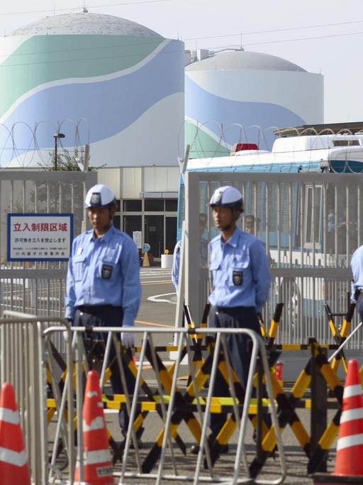 Sicherheitskräfte vor dem Atomreaktor Sendai in Japan