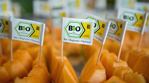 Kleine Fähnchen mit der Aufschrift "Bio+Regional=Optimal" stecken in Filderstadt im Bioland-Gemüsehof Hörz in Stücken von Hokkaidokürbissen.