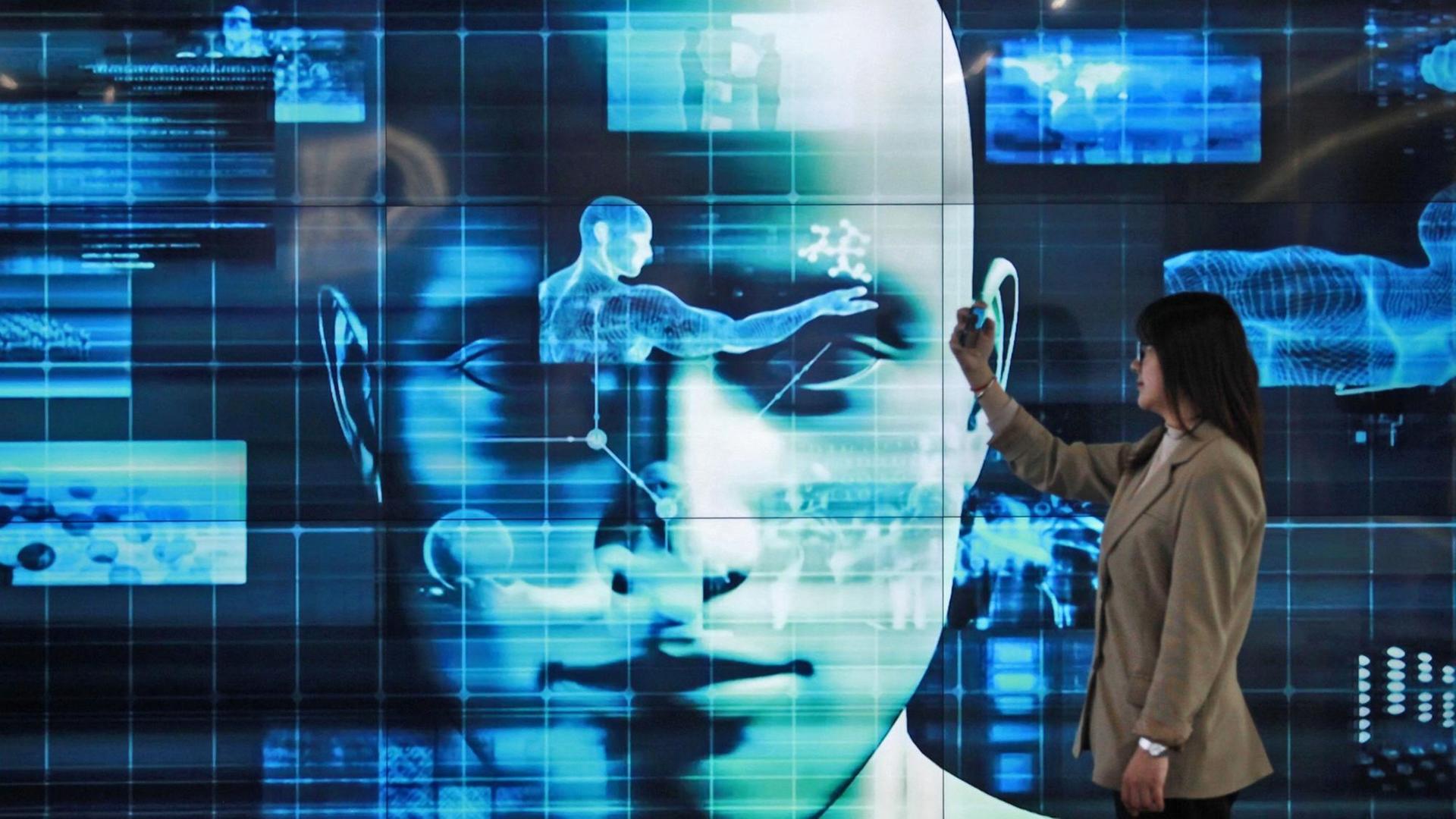 Eine Besucherin hat eine Fernbedienung in der Hand und steht vor einem Bildschirm, auf dem eine digitale Darstellung einer Person zu sehen ist. Eine Besucherin hat eine Fernbedienung in der Hand und steht vor einem Bildschirm, auf dem eine digitale Darstellung einer Person zu sehen ist.
