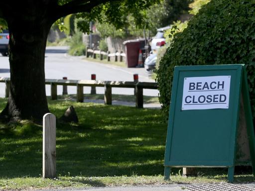 Ein Schild am West Wittering Beach in West Sussex. Durch den Coronavirus-Lockdown ist in Großbritannien das öffentliche Leben weitgehend zum Erliegen gekommen.