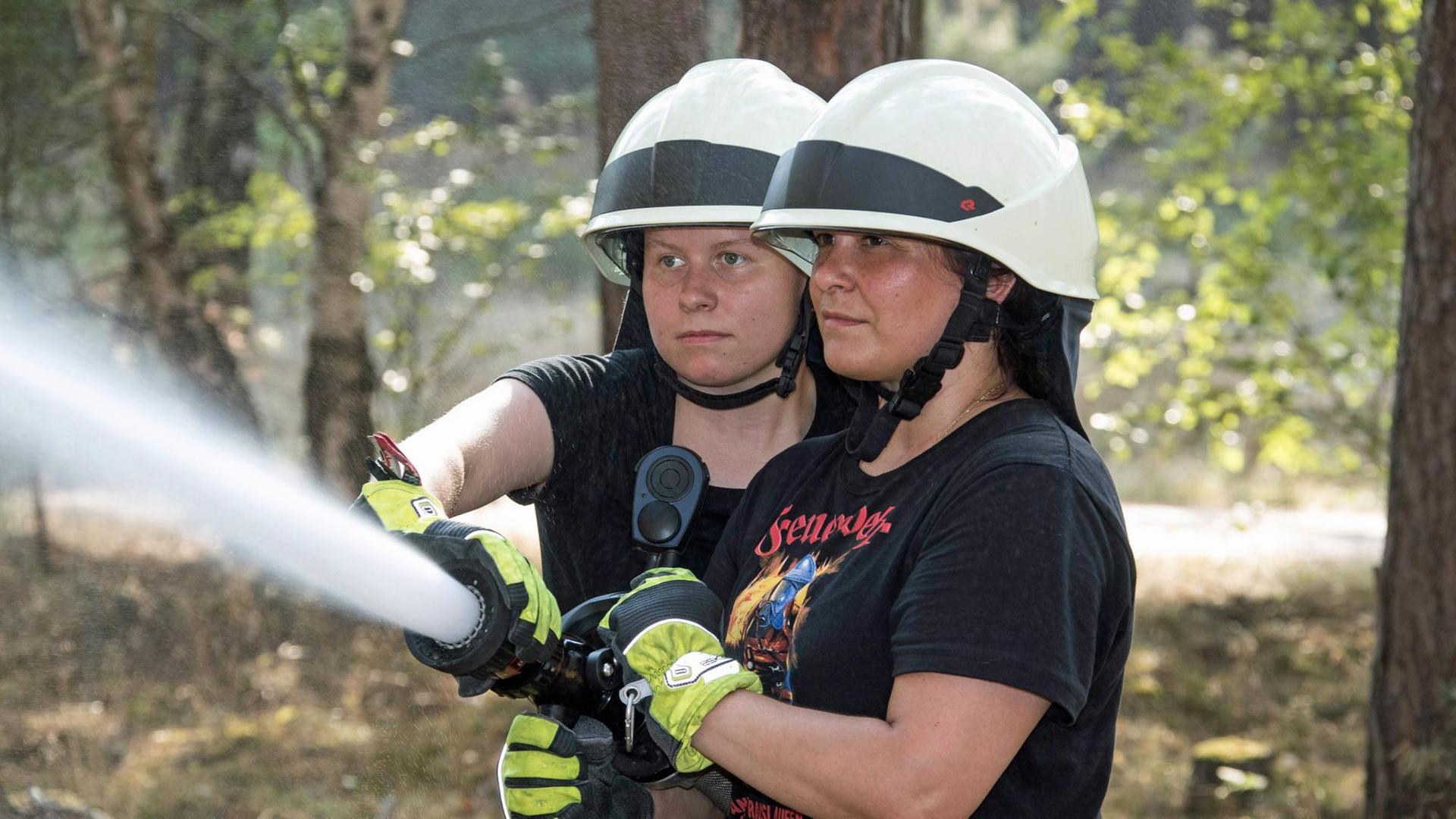 Waldbrand im Sommer 2018: Die Lokalpolitikerin Anja Schmollack (CDU) und Marie-Therese Stolze, beide engagiert bei der Freiwilligen Feuerwehr, löschen mit einem C-Rohr Glutnester.