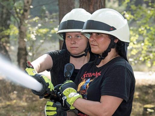 Waldbrand im Sommer 2018: Die Lokalpolitikerin Anja Schmollack (CDU) und Marie-Therese Stolze, beide engagiert bei der Freiwilligen Feuerwehr, löschen mit einem C-Rohr Glutnester.