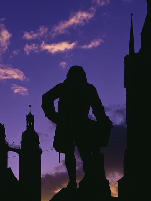 Silhouetten des Händeldenkmals, der Türme der Marktkirche und des Roten Turms vor Abendhimmel.