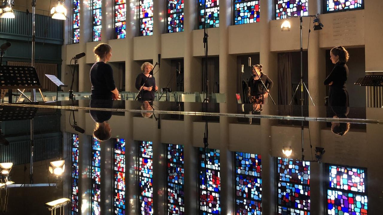 Auf dem Rücken eines Flügels spiegeln sich die Kirchenfester vor dem probenden Ensemble. Auf dem Rücken eines Flügels spiegeln sich die Kirchenfester vor dem probenden Ensemble.