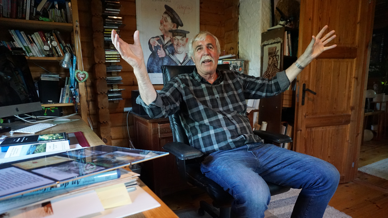 Robert Volkmann sitzt in seinem Zimmer und erzählt gestikulierend. Robert Volkmann sitzt in seinem Zimmer und erzählt gestikulierend.